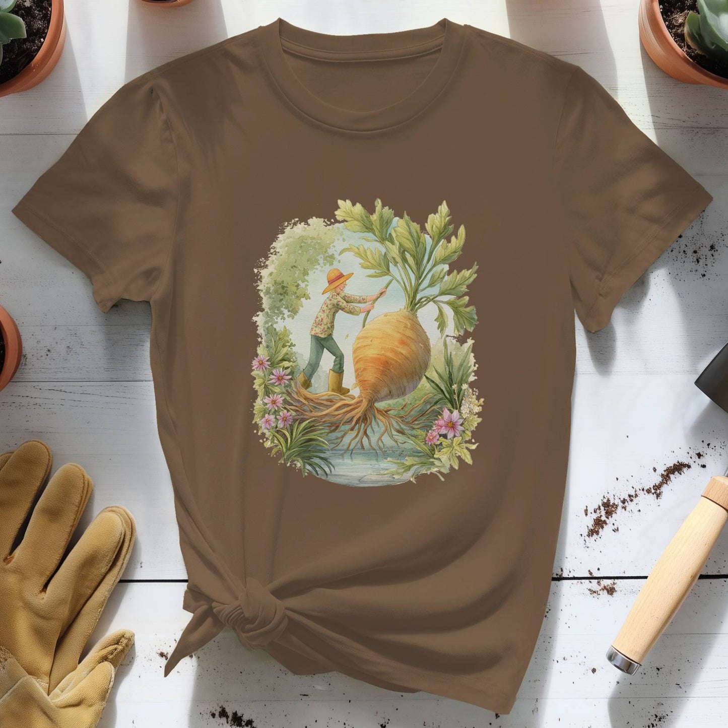 Brown t-shirt with a garden-themed design on a white surface with gardening tools and plants.