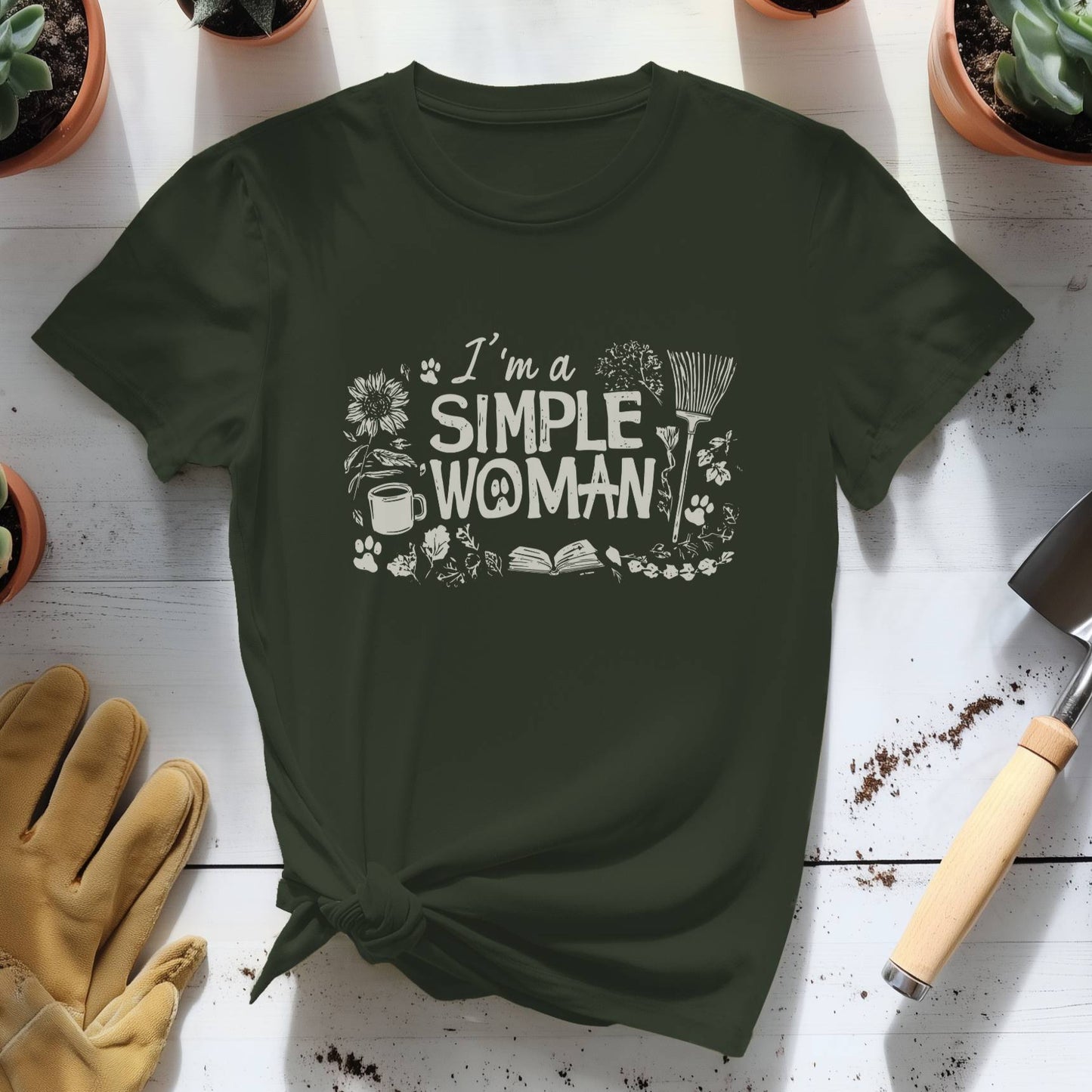 Green t-shirt with 'I'm a Simple Woman' text on a wooden surface with gardening tools and plants.